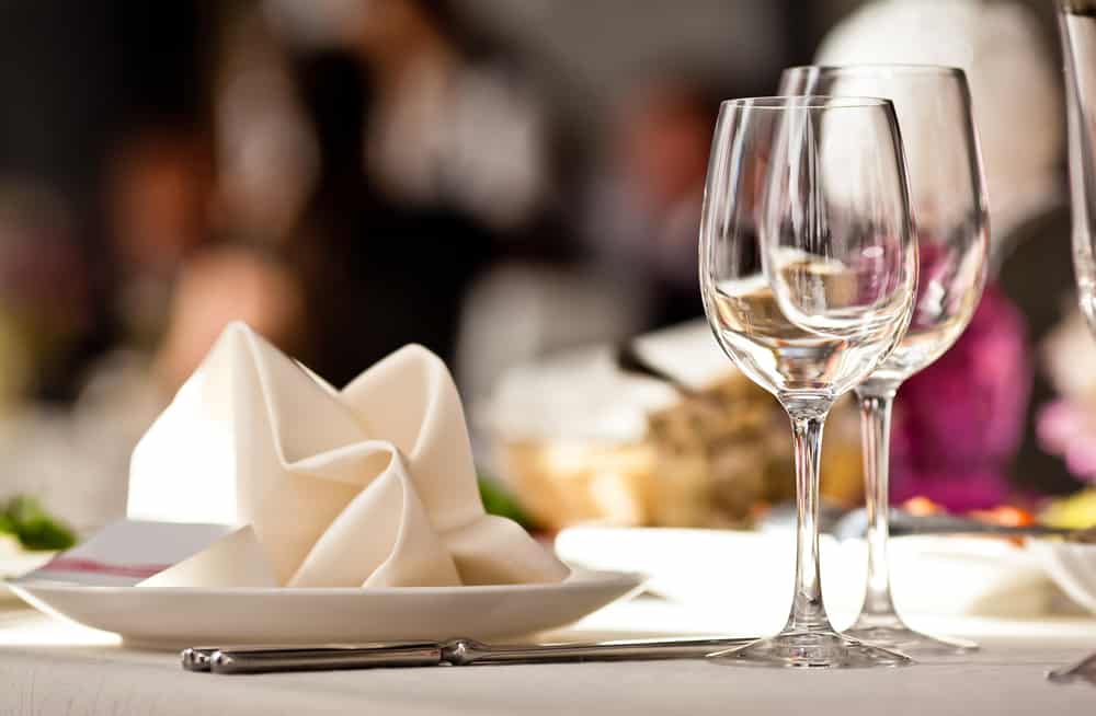 Plate with napkin and empty wine glasses at restaurant