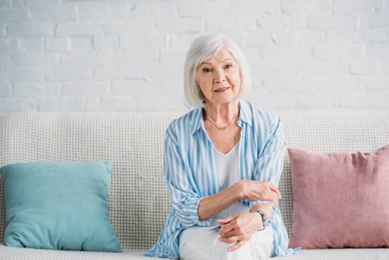 Senior woman sitting on couch at home
