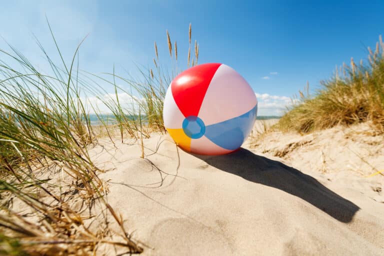 Beach ball in sand dune on beach