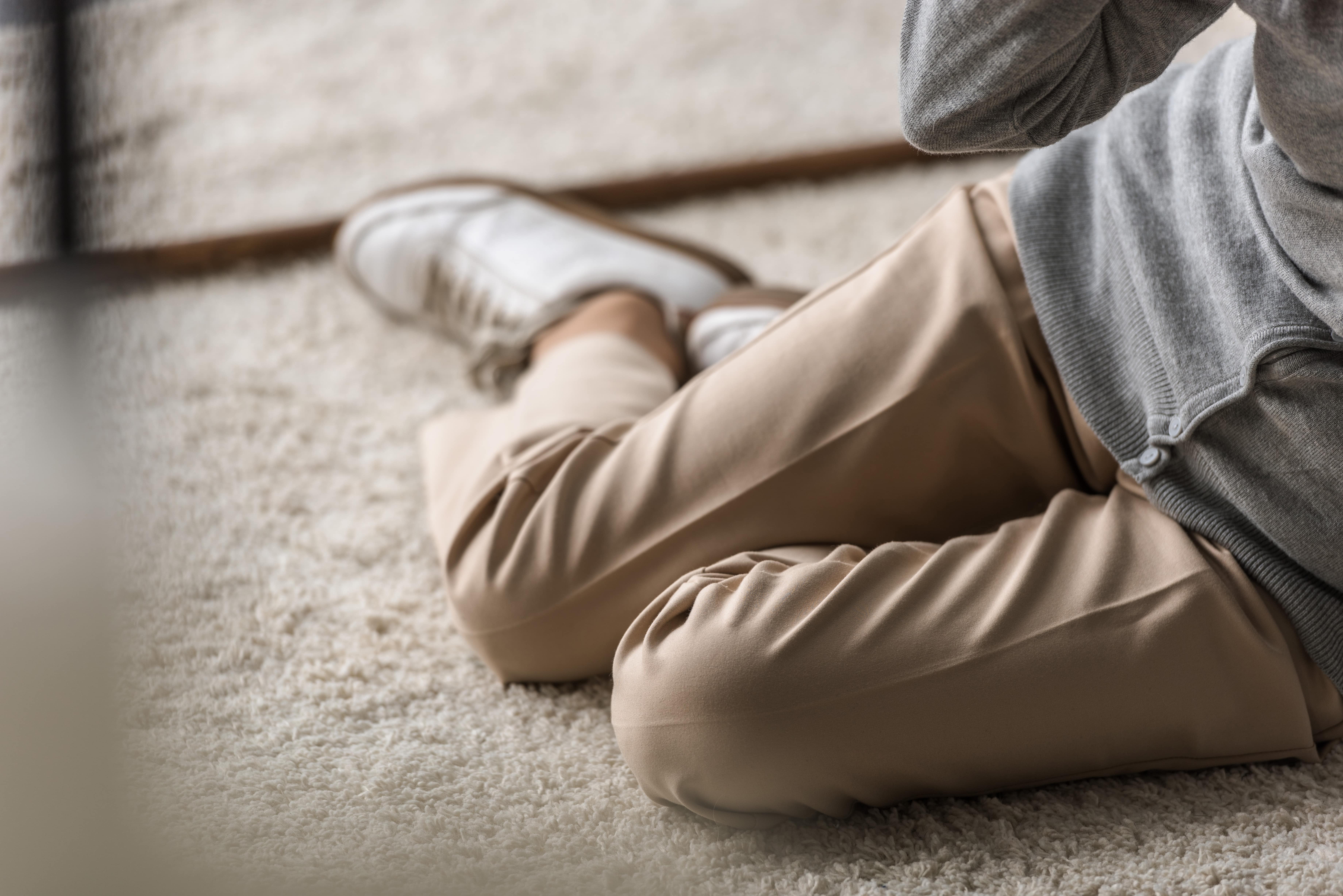 Senior woman legs and feet on carpet, having fallen