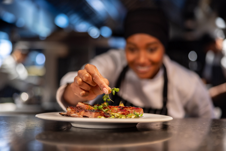 Close-up on a chef decorating a plate at a restaurant
